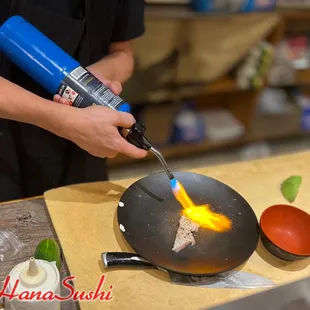 a person cooking food in a wok
