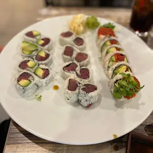 a variety of sushi rolls on a white plate