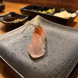 a piece of tuna on a black plate