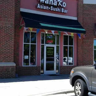 a truck parked in front of a asian sushi bar