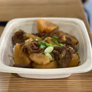 a bowl of beef and potatoes