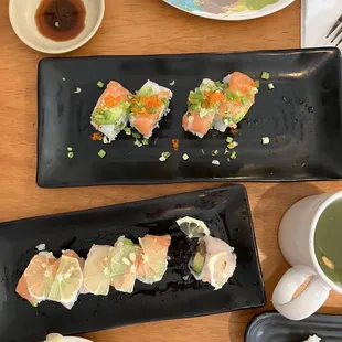 a variety of sushi on black plates