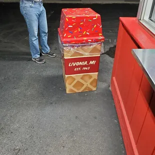 a man standing next to a box of donuts