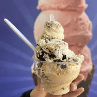 a hand holding a cup of ice cream