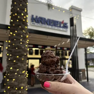 a hand holding a bowl of ice cream