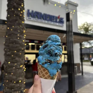 a hand holding a cone of ice cream