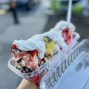 a hand holding a container of ice cream