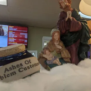 a statue of jesus and a jar of jam