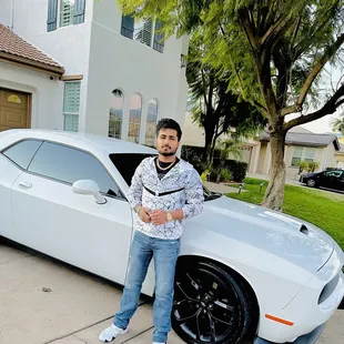  a man standing in front of a white sports car