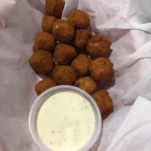 a basket of fried tater tots with dip