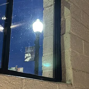 a window with a street light reflected in it