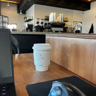 computer with a coffee and view of barista bar