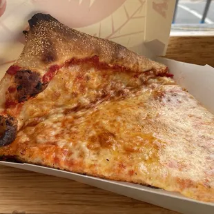 Pizza slice was so big it had to be folded a bit to fit in the box