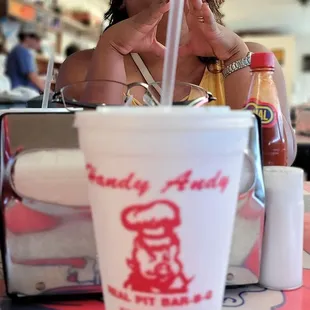 a woman sitting at a table with a drink in her hand