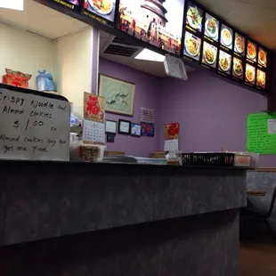 a restaurant counter with menus on the wall