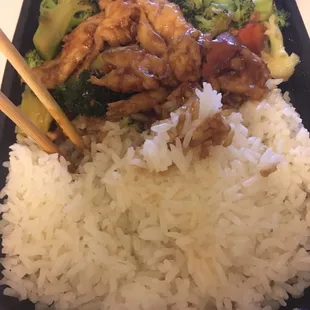 a plate of rice, broccoli, and chicken with chopsticks