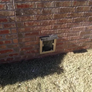 Doggie door through brick wall.