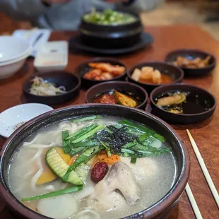 a bowl of soup with chopsticks on a table