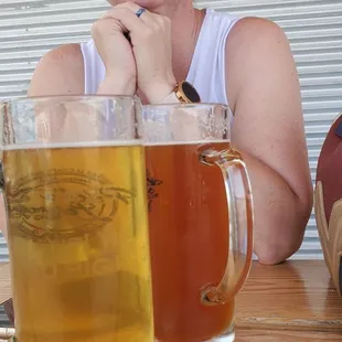 a woman sitting at a table with beer