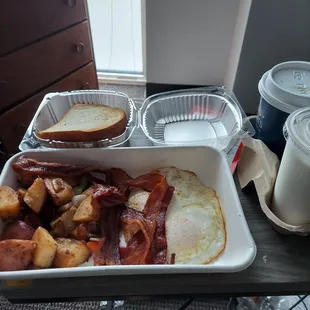 2 eggs over easy, bacon, country potatoes, wheat toast, milk, and coffee
