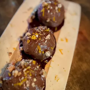 three chocolate covered donuts