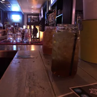 a glass of iced tea on a bar