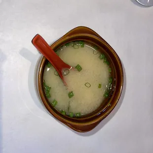 a bowl of soup with a red spoon