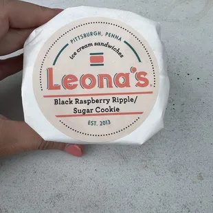 a person holding a bag of leona&apos;s black raspberry ripplele