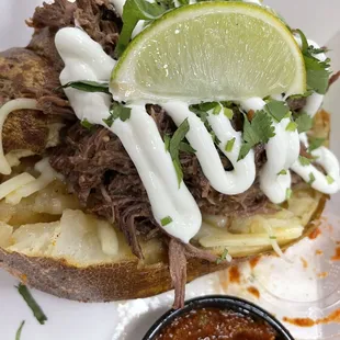 a pulled pork sandwich with a side of salsa