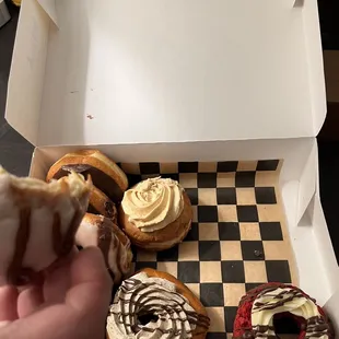 a hand holding a half eaten donut