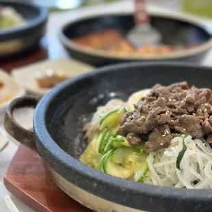 Hot stone beef Bibimbap and kimchi pancake in the background