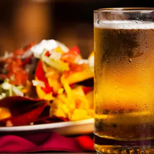 a glass of beer and a plate of salad