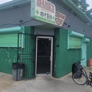 a bicycle parked in front of a green building