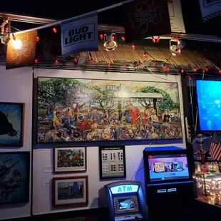 a bar with a large painting on the wall