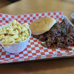a plate of pulled pork, macaroni and cheese