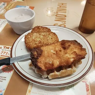 Chicken and waffle with gravy and hash browns.