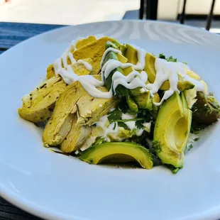 Different angle of my green chilaquiles with chicken and avocado .