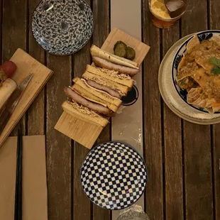 a wooden table with plates of food on it