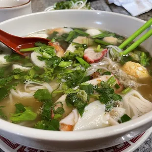 a bowl of soup with chopsticks