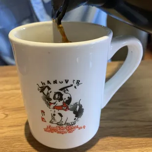 a coffee being poured into a mug