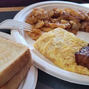 Breakfast platter: scrambled eggs with cheese, home fries,  toast and bacon