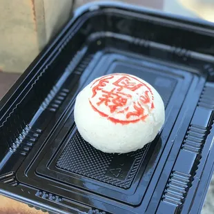 a red and white cake on a black tray