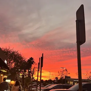 a woman walking down the street at sunset
