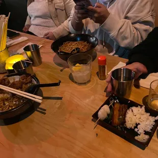 a group of people sitting at a table with food