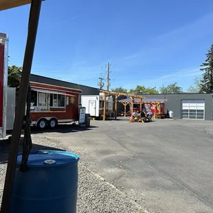 Parking lot. Coffee cart next door. A few wooden picnic tables; about 4 more tables not pictured (behind us).