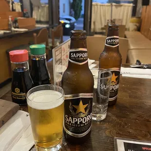 a glass of beer and a bottle of sappor