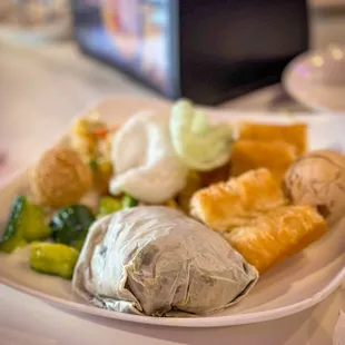 plate full of food and sticky rice wrapped in lotus leaf