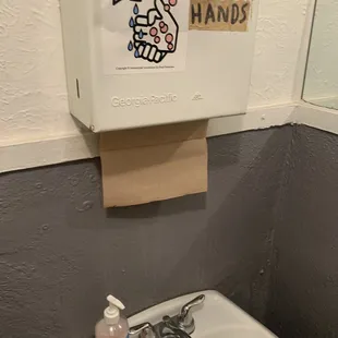 a bathroom sink with hand sanitizer