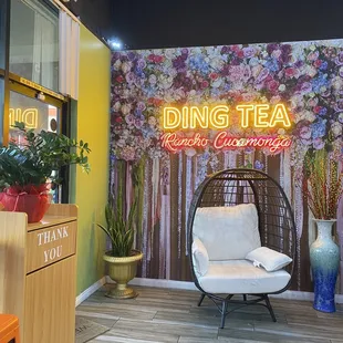 a hanging chair in front of a sign that says ding tea
