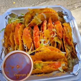 a tray of tacos with sauce